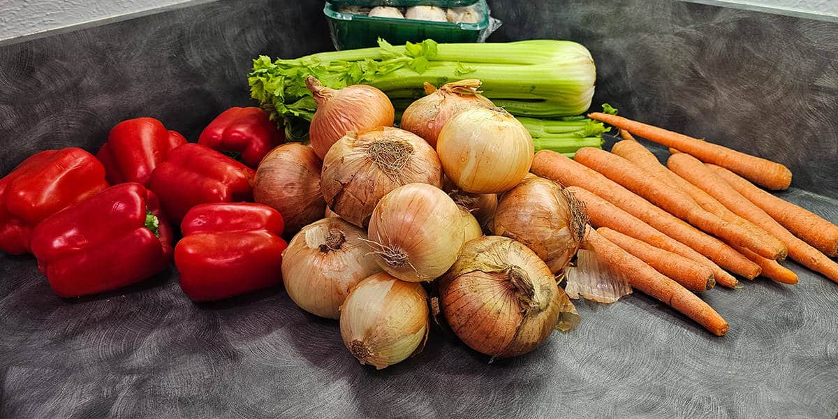 Fresh vegetables for making holy trinity on a counter.