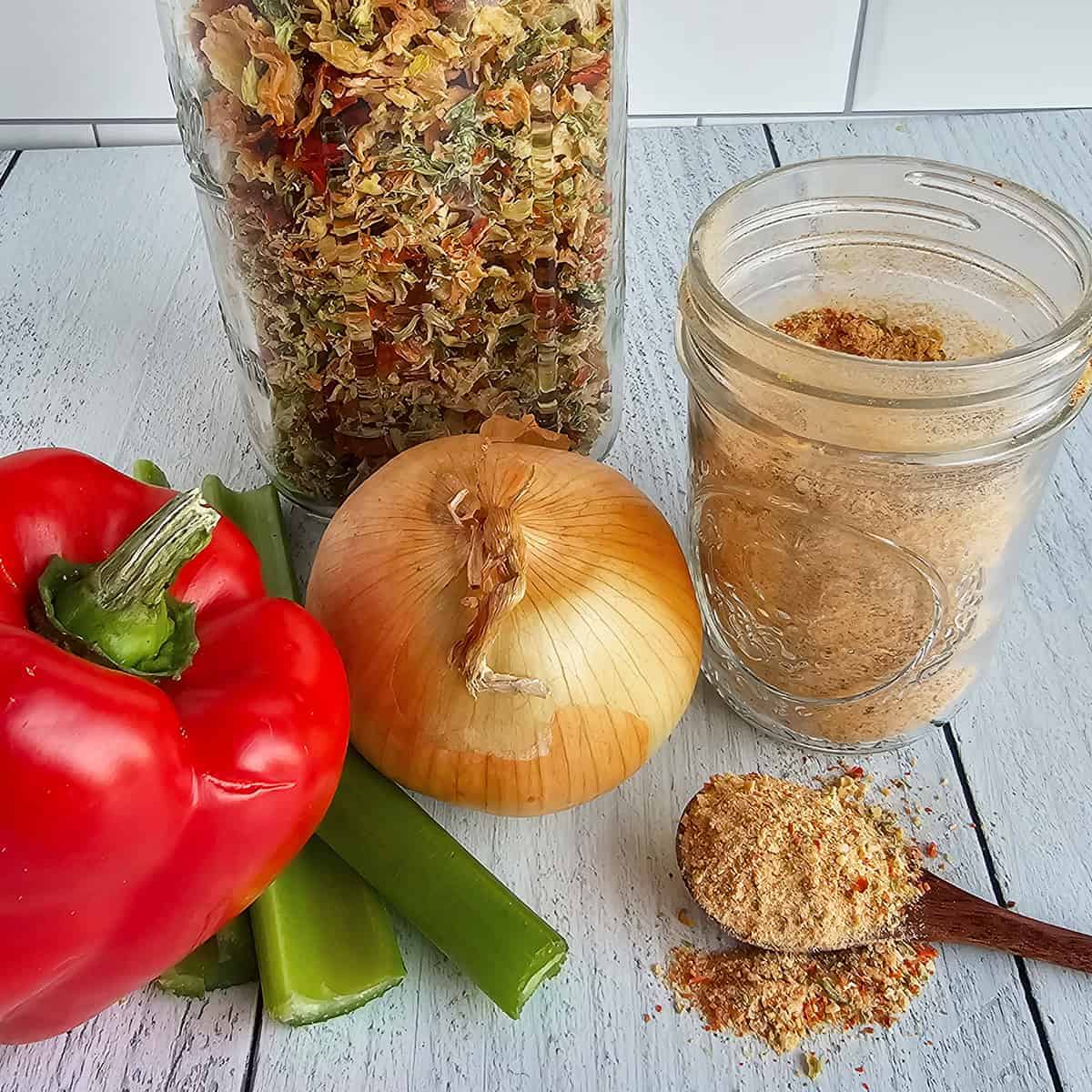 A jar of holy trinity seasonings, celery, onions and peppers on a wooden table.