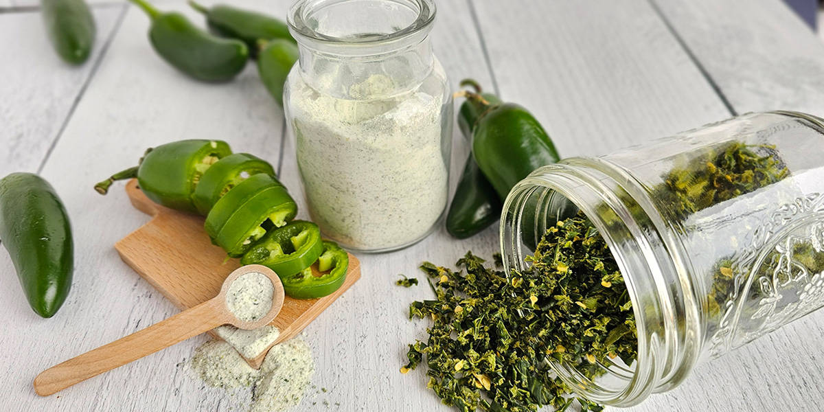 Jalapenos and other ingredients to make jalapeno salt all on a wooden table.