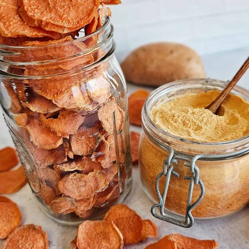 Sweet potato chips in a jar with a wooden spoon.