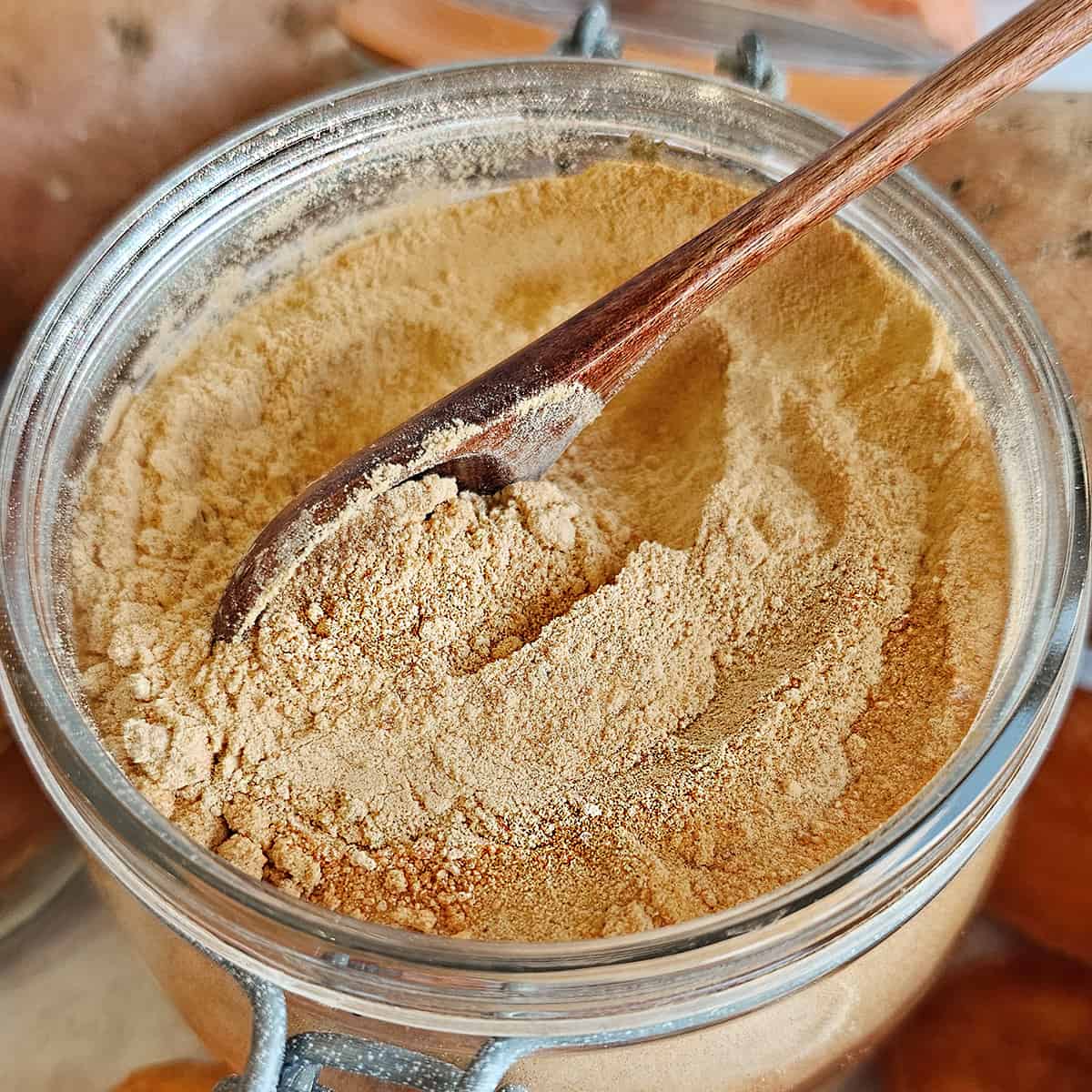 Sweet potato powder in a jar with a wooden spoon.