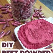 A jar of beet capsules next to a white plate of beet powder.