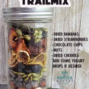 A jar full of dried fruit and nuts in front of a wooden background.