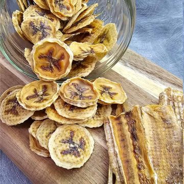 Banana chips on a wooden cutting board.