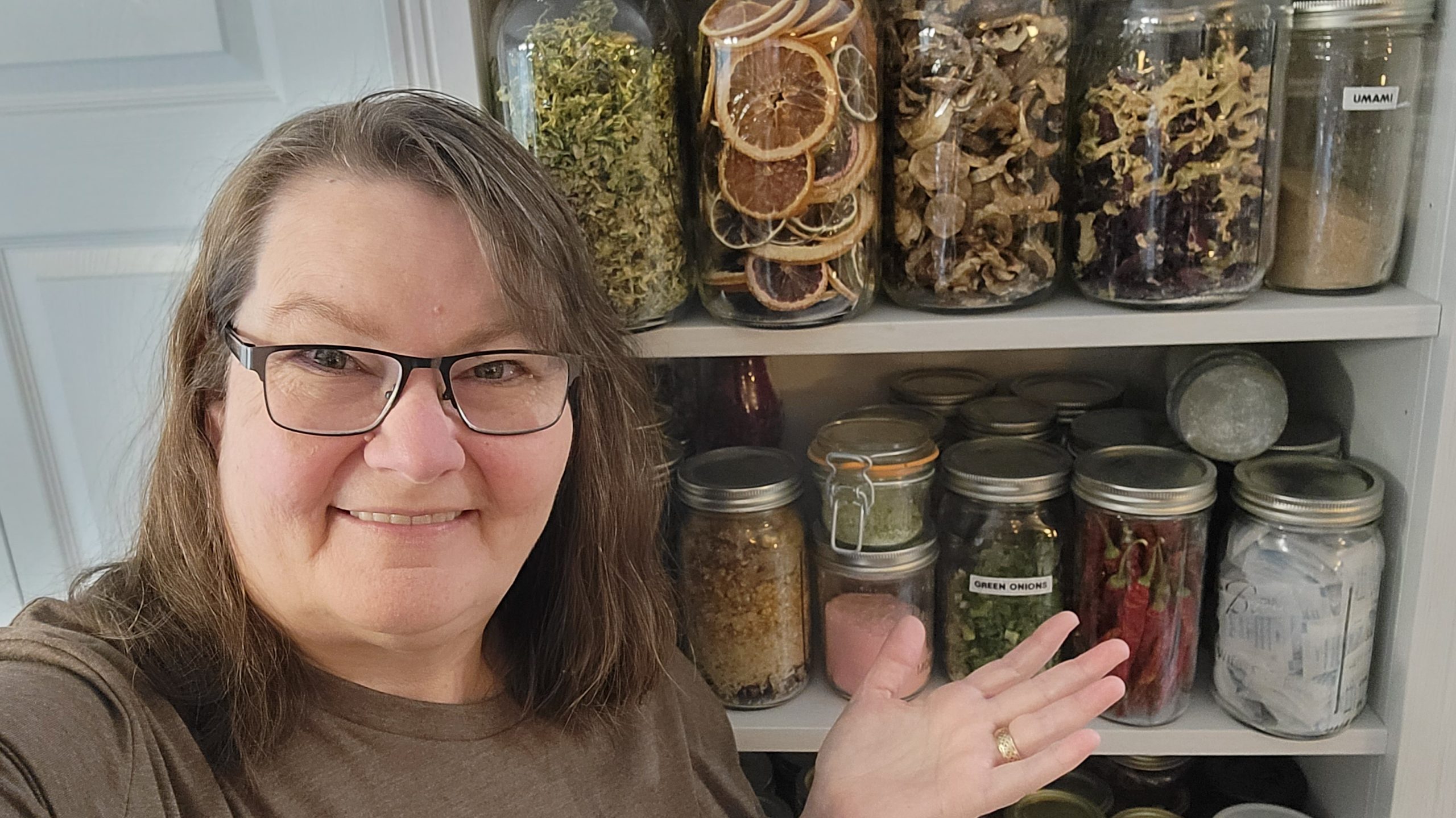 Darcy of the Purposeful Pantry standing in front of her dry pantry.