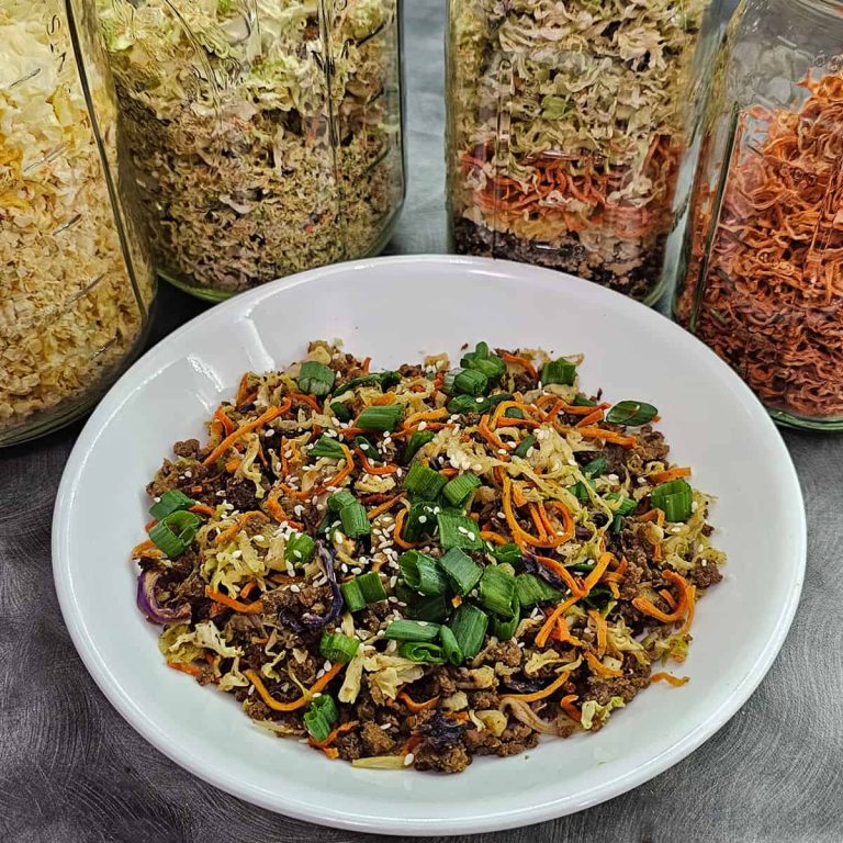 A bowl of Eggroll in a Jar in front of jars of dehydrated vegetables.