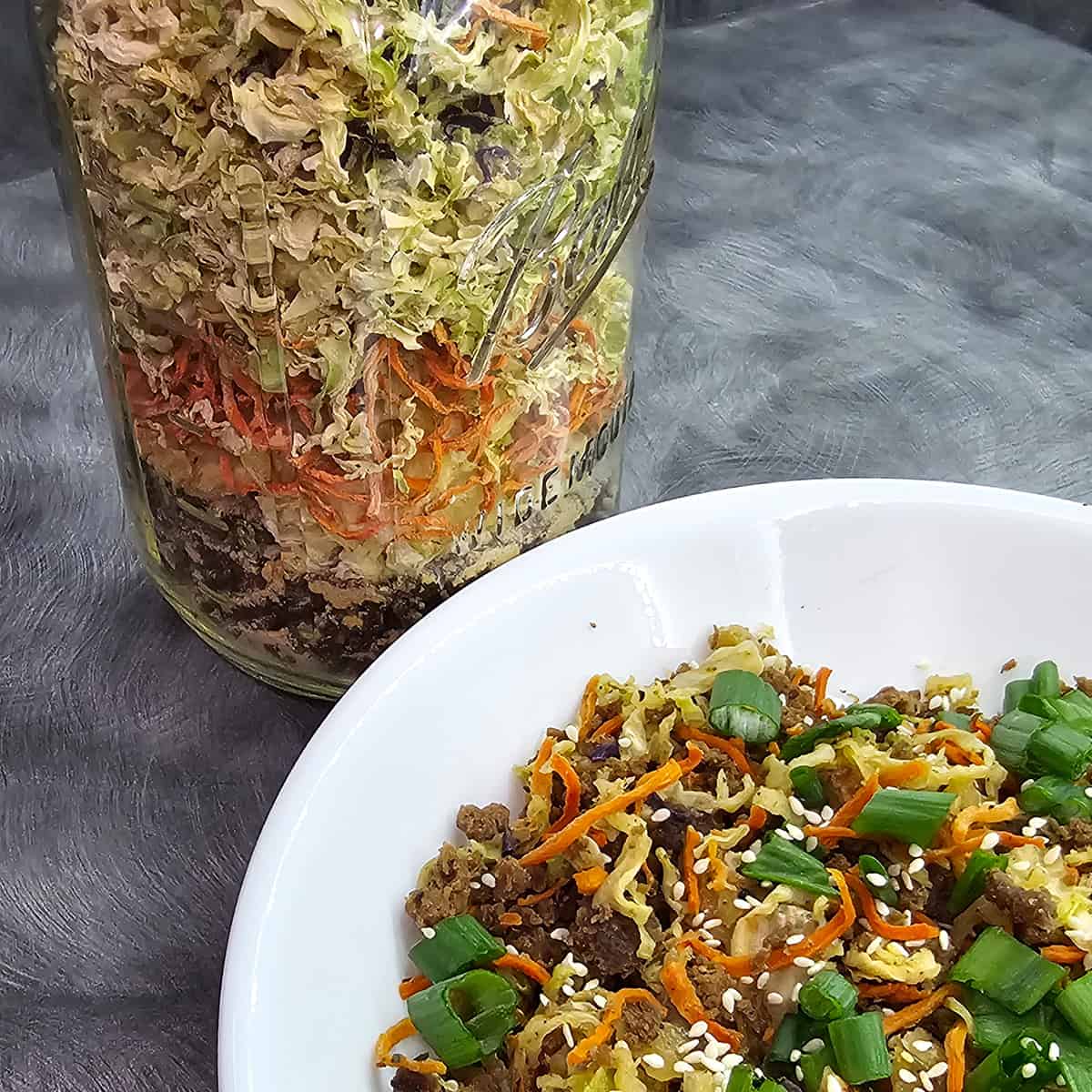 Eggroll in a Bowl dehydrated recipe with rehydrated Eggroll in a Jar in a white bowl.